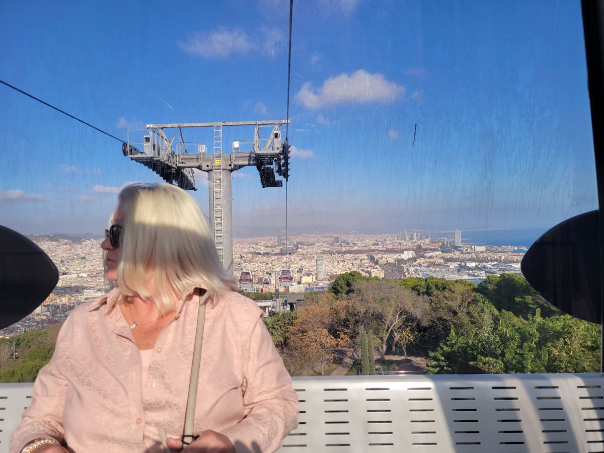 Shirley looking out from the Montjuïc cable car with Barcelona's skyline and harbor stretching out below