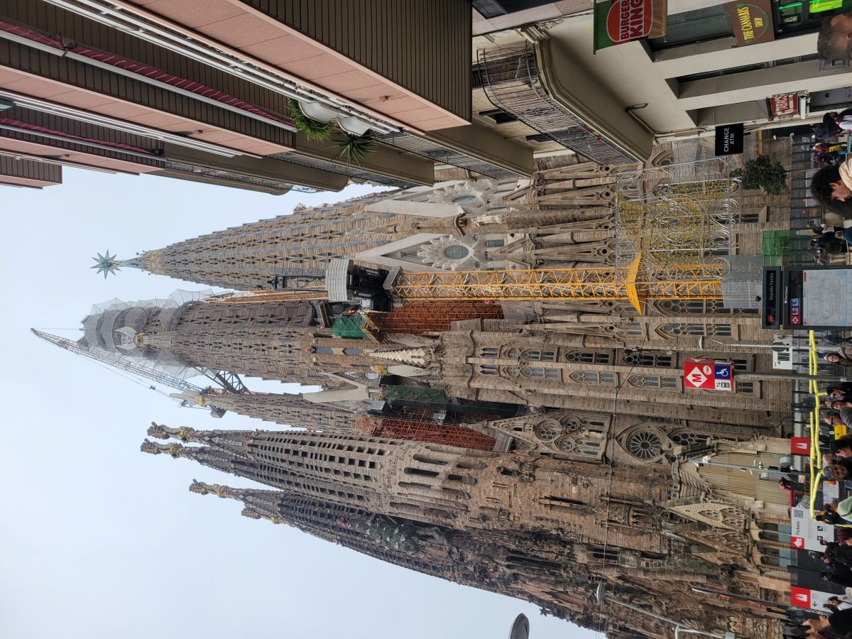 Sagrada Família exterior with towers and construction cranes, view from the street
