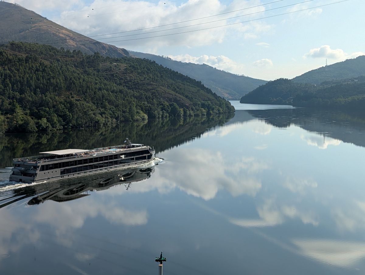 A river cruise ship on the Douro with clouds reflected in the still water