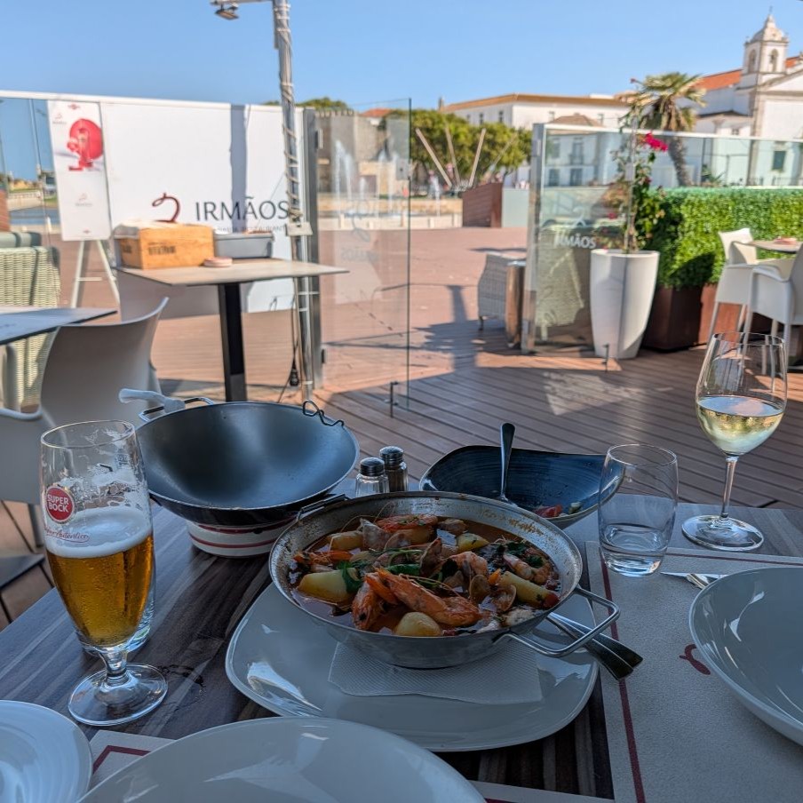 A cataplana dish of fish, prawns and clams at restaurant Irmãos on the Lagos waterfront, a Super Bock beer and glass of white wine alongside