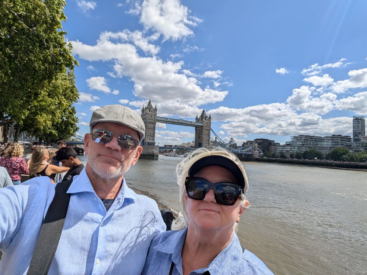 Keith and Shirley selfie on the Southbank with Tower Bridge rising behind them, the Thames between