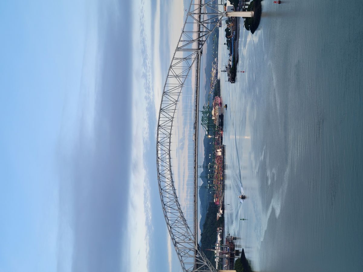 Bridge of the Americas at dusk with a busy container port below, Panama City