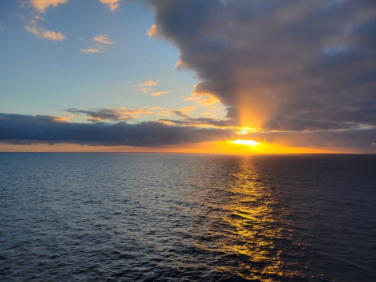Golden Pacific sunset with sun rays breaking through dramatic clouds