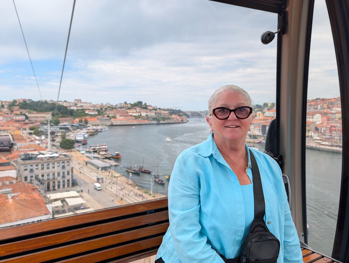 Shirley in the Teleférico de Gaia cable car, with the Douro River and Porto behind her